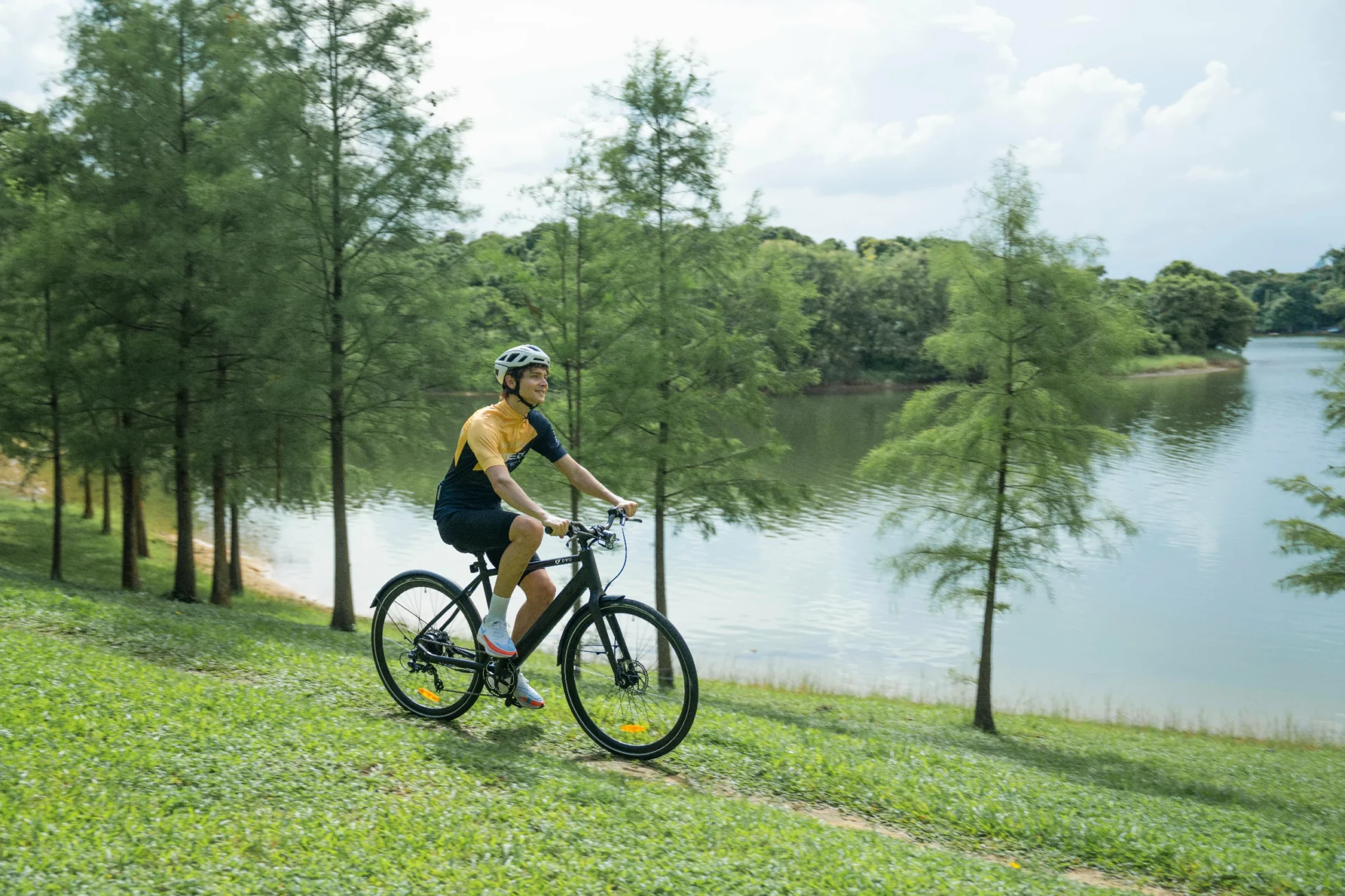 DYU e-bike rider on a riverside route for an e-bike water resistance guide